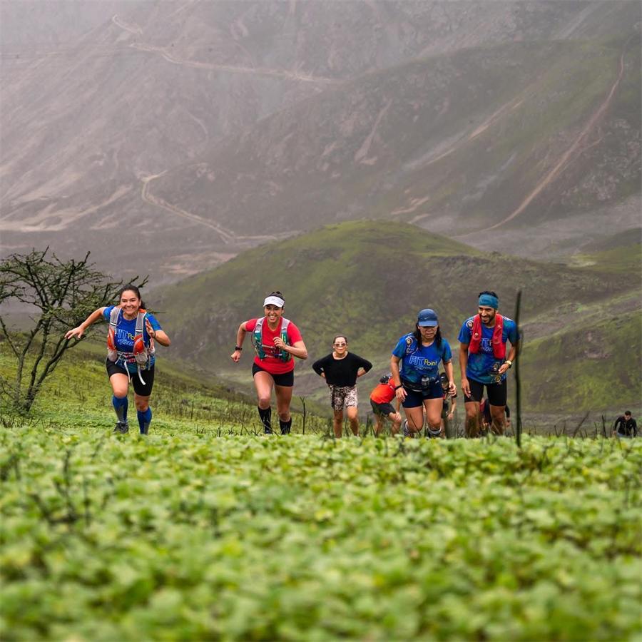 Corredores subiendo una ladera cubierta de vegetación
