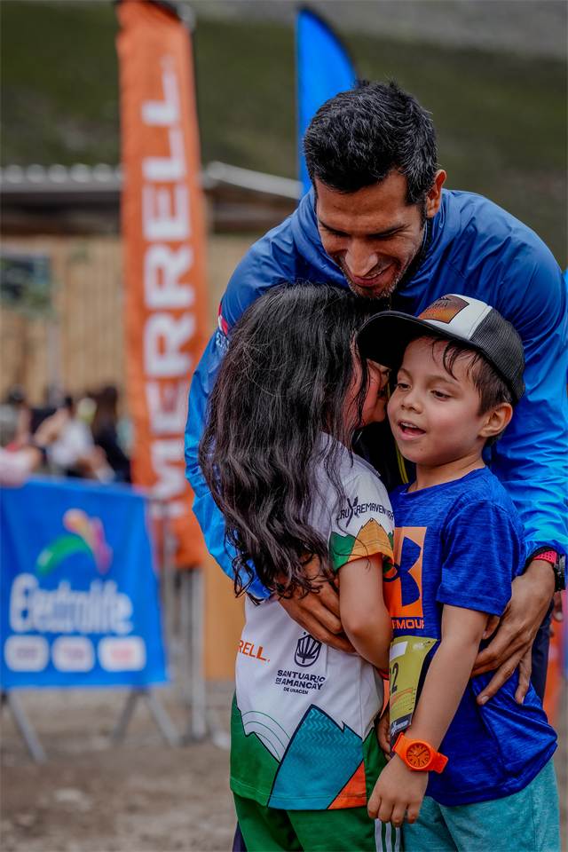 Padre abrazando a sus dos hijos al terminar la carrera