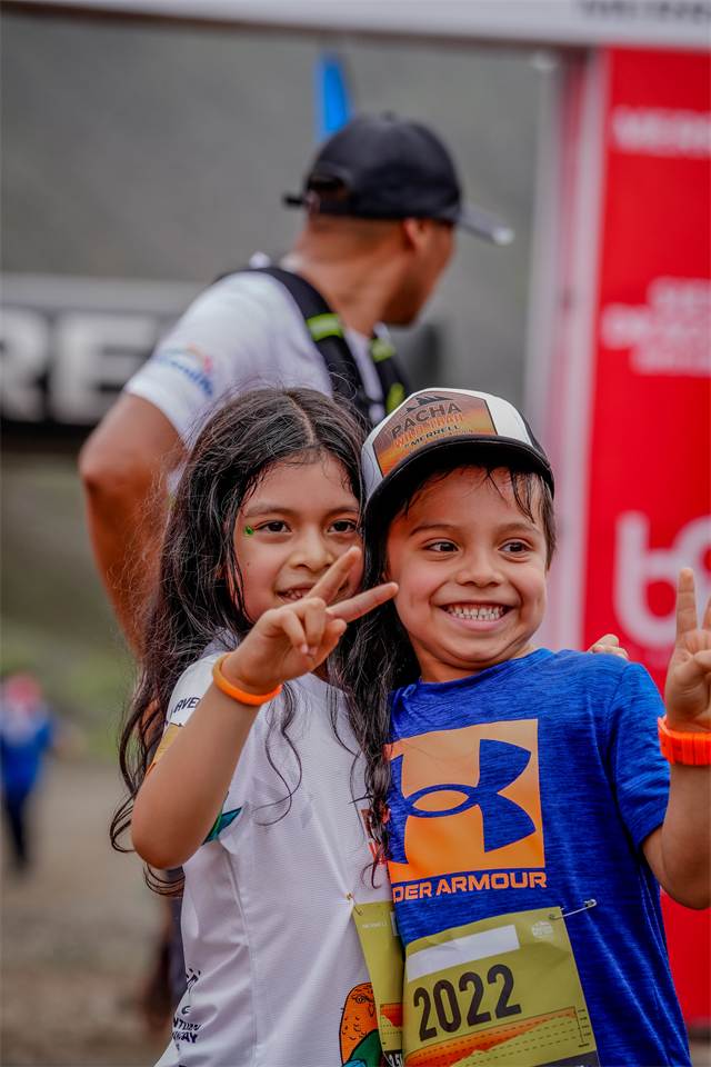 Dos niños posando con sus dorsales después de llegar