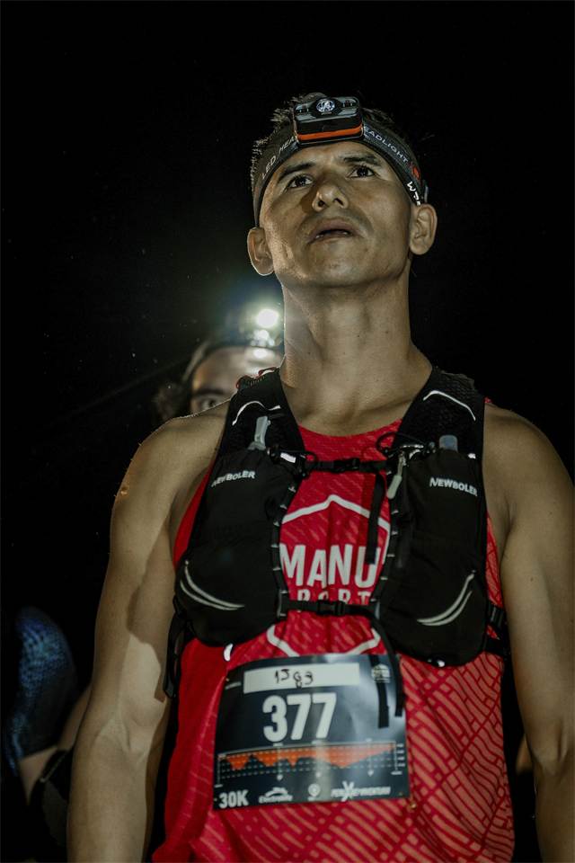 Retrato de un corredor de 30 K concentrado antes de la salida nocturna