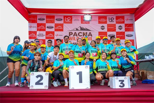 Equipo completo de corredores juveniles celebrando en el podio